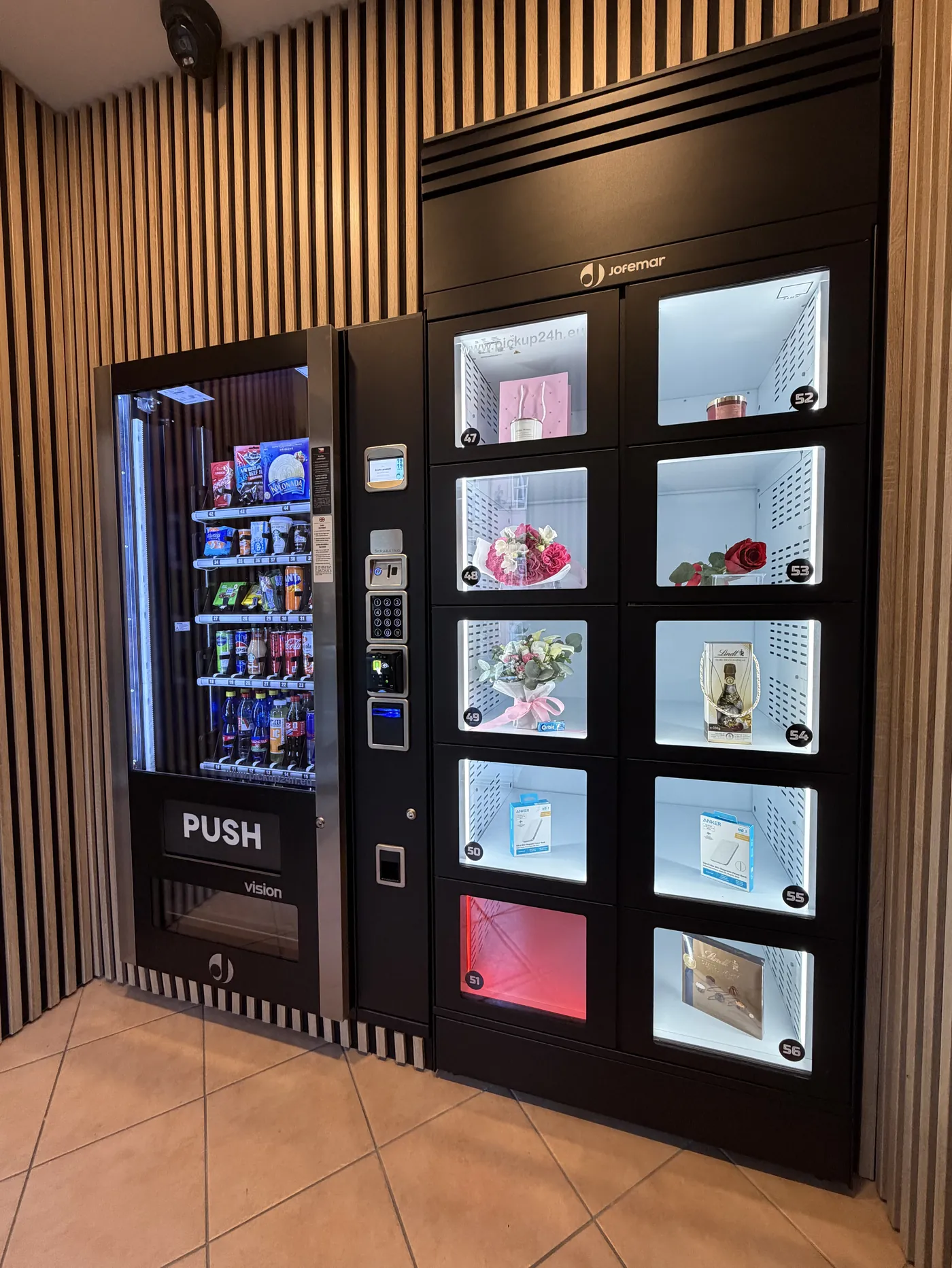 Automat s občerstvením a květinové boxy vedle sebe